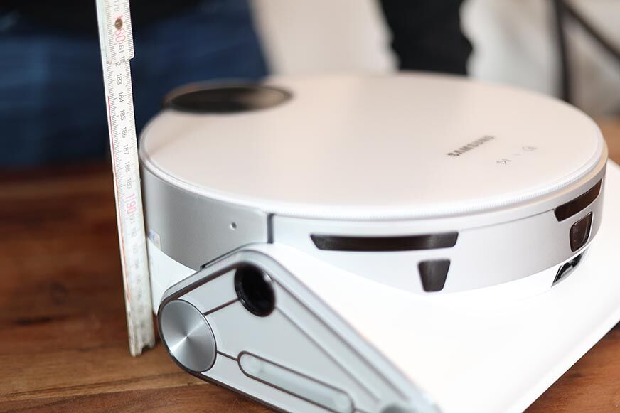 Der Samsung Jet Bot AI Saugroboter wird mit einem Lineal ausgemessen.